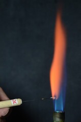 Colored fire caused by an element. Potassium (K) causes an orange-pink color