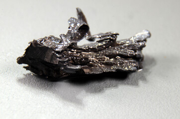 Piece of Strontium (Sr) The piece is covered with a thin layer of oil to prevent air contact