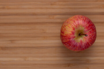 One fresh red apple on a wooden background. Fresh and healthy breakfast fruit.