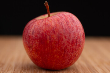 One fresh red apple on a wooden background. Fresh and healthy breakfast fruit.