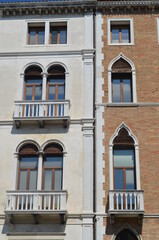 
contrast between the facades of two buildings, one smooth white and the other in exposed red bricks