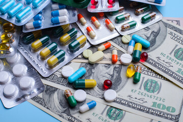 Obraz premium Cost of treatment, medicine, happy life without diseases concept. different pills lay on dollar bills symbolising high price on medicine