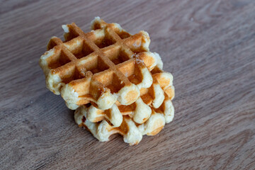 A delicious baked round Belgian waffle with one bite taken.