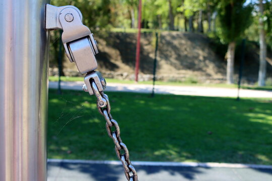 Metal Construction With Bolt And Iron Shiny Thick Chain On Blurred Background . Metal Chain Of A Swing Set Seat In Soft High Key Focus