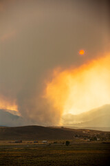 Mountain and valley landscape with wildfire smoke obscuring the sun
