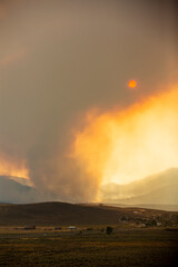 Fototapeta na wymiar Mountain and valley landscape with wildfire smoke obscuring the sun