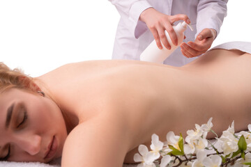 Obraz na płótnie Canvas Crop masseur applying cream before massage in salon