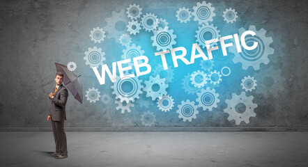 Businessman defending with umbrella from WEB TRAFFIC inscription, technology concept