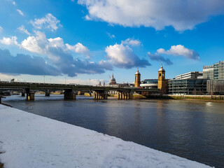 Fototapeta premium Sunny sunshine winter day snow in London city before towers bridge crane buildings skyscraper shine blue sky thames uk