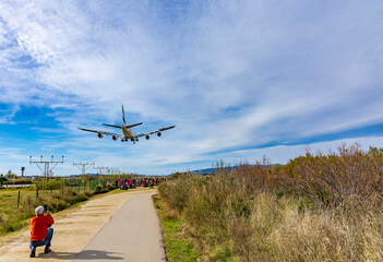 Fototapeta na wymiar Planes landing at Barcelona airport and people watching