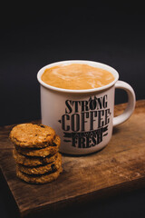 Vertical closeup focus shot of a coffee mug next to cookies
