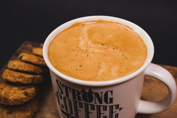 Closeup focus macro shot of a coffee mug next to cookies