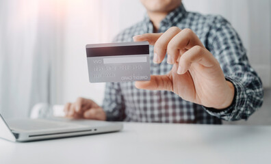 Business people use tablets and hold credit cards as an online shopping concept With a calculator and a book placed on the table