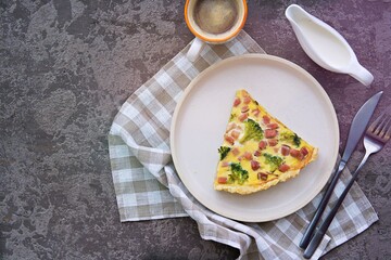 Open savory shortcrust pastry pie with ham, broccoli and egg filling on a gray concrete background. Breakfast for two on Valentine's Day. Savory pies.