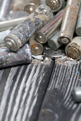 Corroded used batteries. On pine boards. Disposal of hazardous waste. Close-up shot.