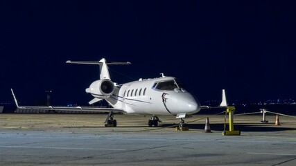 Front side view of white business airplane with jet engines. Night dark blue sky. Modern technology...