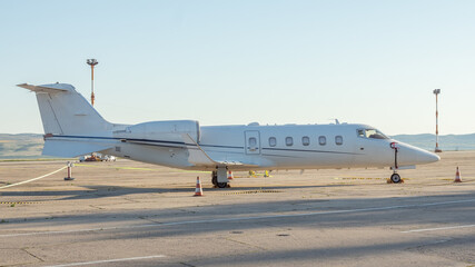 Side view of white business airplane with jet engines  at the airport. Modern technology in fast...