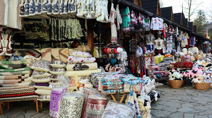 Souvenir market in Yaremche with traditional Carpathian handmade clothing, herbs and wooden tools. Ukrainian textiles, knitted socks, vests, hats. 
