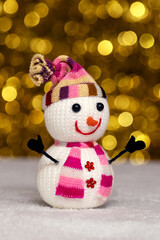 Toy snowman on a golden blurred background with bokeh