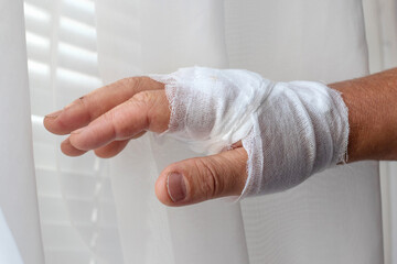 Man's hand with a bandage after injury