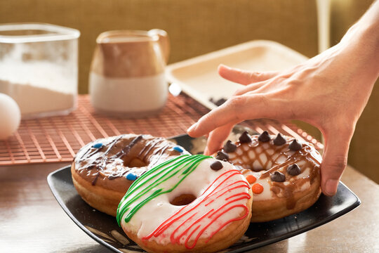 Agarrando donas deliciosas, exquisitas para el desayuno o cena