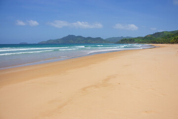 Empty tropical beach on sunny day. Duli beach in Palawan, Philippines. Surf beach. Wide beach with island on background. Travel in Asia. Tropical landscape. Azure water in idyllic lagoon. 