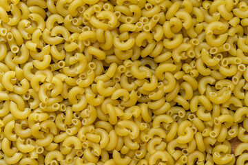 Full background of dry uncooked macaroni pasta