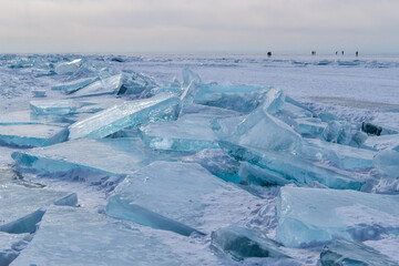 large iridescent crystals blue white ice floes with cracks glow in the light of the sun, lake baikal in winter, horizon