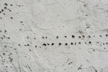 Grey concrete wall covered with cracks