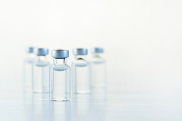 Many transparent vials with vaccine for covid-19 coronavirus, flu, infectious diseases. Injection after clinical trials for vaccination of human, child, adult, senior. Medicine, drug concept