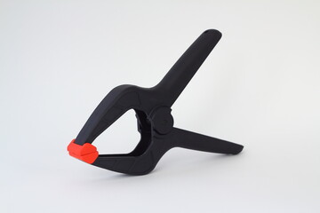 Obraz premium Single black plastic spring clamp isolated over white background