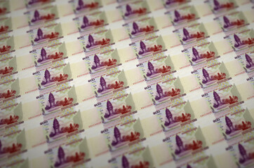 100 Cambodian riels bills printed in illegal money production conveyor. Collage of many fake bills....
