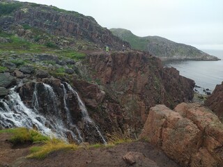 High cliffs and waterfalls on the coast of the Barents sea Arctic ocean