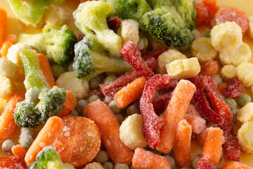 Mix of frozen vegetables: paprika, carrot, broccoli, mini corn, tomato and green pea. Close up.