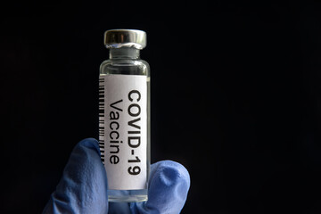 COVID-19 vaccine on black background, medication bottle for SARS-CoV-2 corona virus cure