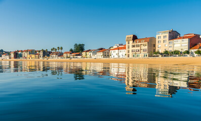 Fototapeta na wymiar Reflections of buildings in a Galician beach