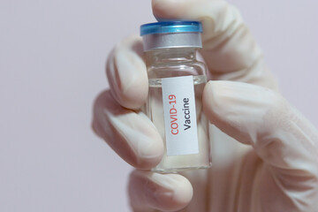 Vaccine COVID-19 (Coronavirus) glass bottle in medical doctor hand
