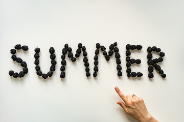 Inscription Summer made with blackberries on white background