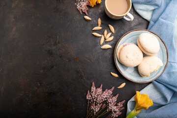 Meringues cakes with cup of coffee on a black concrete background. Top view, copy space.