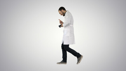 Walking attractive laughing doctor on gradient background.