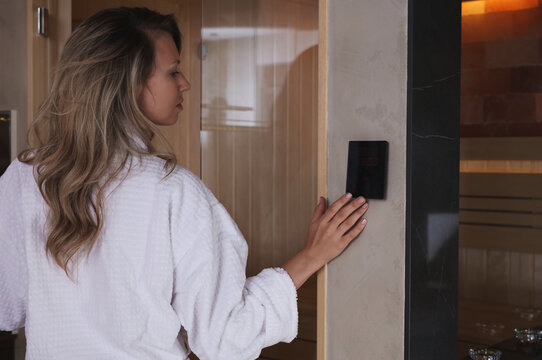 Woman choosing infrared sauna temperature. Home Spa concept