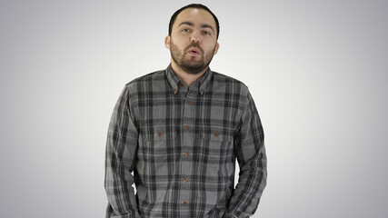 Young man walking and whistling on gradient background.