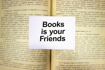 Obraz premium Books is youe friends written in white note on open book