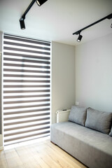 Gray sofa in a small room. Big window. The concept of interior, home and comfort