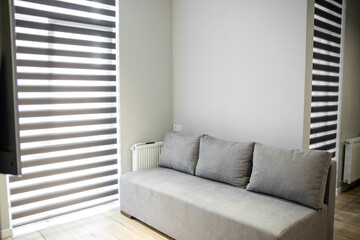 Gray sofa in a small room. Big window. The concept of interior, home and comfort