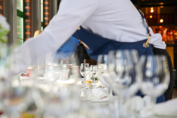 a gloved waiter sets the table

