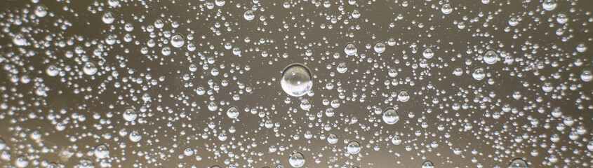 Panoramic photo background of air bubbles on the water surface. Close-up shot of air bubbles in liquid. Selective focus.
