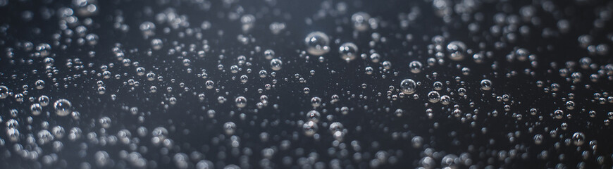 Panoramic photo background of air bubbles on the water surface. Close-up shot of air bubbles in...