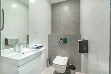 White and grey modern toilet with a hand dryer