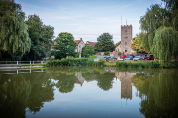 an old english church reflecting on a lake